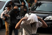 Para tersangka berjalan menuju Mapolres Jakarta Selatan sambil menundukkan kepala.