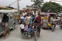 Meskipun demikian, Anak-anak sekolah ini tampak senang menaiki becak usai menghadiri sekolah di komunitas kumuh Baseco, di Tondo, Manila.