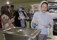 Ketua rombongan Choirunusa melihat proses pengepakan makanan sebelum di distribusikan ke jamaah.