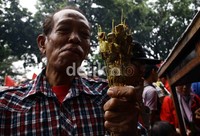 Seorang warga terpaksa mengambil makannya tidak mengunakan piring karena terbatasnya alat-alat makan.