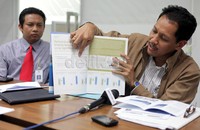 Tri Poetra menunjukan laporan tahunan 2011 yang memperoleh penghargaan Stevie Award.