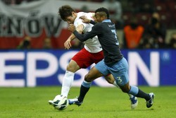 Ashley Cole berebut bola dengan Grzegorz Krychowiak. Reuters/Kacper Pempel.