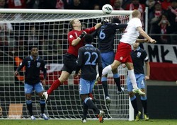 Kamil Glik menyundul bola yang berbuah gol ke gawang Inggris di menit ke-70. Hasil imbang ini tak mengubah posisi kedua tim di klasemen sementara Grup H. Inggris tetap di urutan teratas, sedangkan Polandia di posisi ketiga. Reuters/Kacper Pempel.