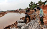 Sejumlah pekerja sibuk menyelesaikan proyek pelebaran Kali Pesanggrahan, Jakarta.