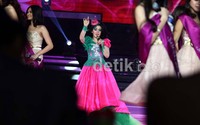 Gaun berwarna hijau dan pink yang dipadu dengan pita berbentuk topi kecil semakin menambah kesan barbie.