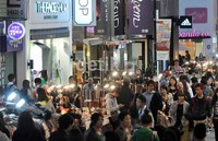 PKL berderet di depan toko dan butik bermerek di kawasn Myeongdong. Semakin malam, kawasan ini semakin ramai.