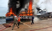 Petugas pemadam kebakaran berjuang memadamkan api dari kapal yang terbakar tersebut.