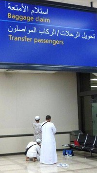 Sambil menunggu proses di pos imigrasi yang cukup memakan waktu, dua orang anggota rombongan ONH Plus dari Indonesia ini melaksanakan salat di pojokan ruang tunggu.