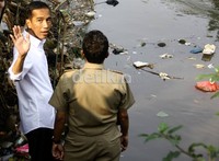 Jokowi melambaikan tangan kepada warga dari tepi Kali Ciliwung. (Ramses/detikcom).