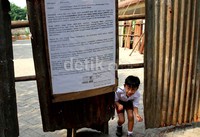 Sejumlah siswa bermain di antara seng yang digunakan sebagai segel.