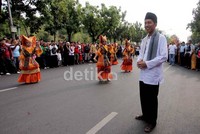 Jokowi menggunakan baju koko atau baju sadariah yang menjadi pakaian tradisi warga Betawi lengkap dengan peci dan sarung yang menggantung di lehernya.