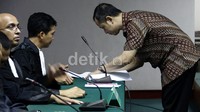 Dhana Widyatmika menandatangani pledoinya di depan JPU. Ramses/detikcom.