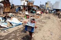 Anak-anak mencari botol bekas di antara puing-puing rumah.