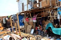 Seorang warga bersama anaknya duduk di depan rumahnya. Rumah-rumah warga yang terletak di Kampung Baru, Muara Angke, tersebut akan digusur oleh Dinas Kelautan dan Pertanian.