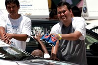 Seorang peserta menggunakan sepatunya untuk melindungi tangannya dari panas.