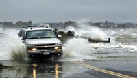 Sebuah mobil nekat menerobos banjir yang ditimbulkan oleh badai Sandy di Southampton, New York. Reuters/Lucas Jackson.