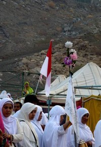 Selain bendera Merah Putih, rombongan ibu-ibu menambahkan bunga sebagai identitas khusus mereka di padang Arafah.