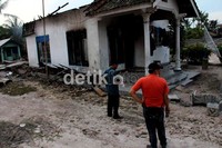 Tampak sebuah rumah hangus dibakar massa.