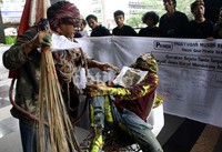 Mereka menggelar aksi teatrikal dengan duduk di atas closet dan membawa sapu lidi. (Ramses/detikcom).