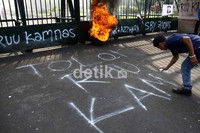 Mereka juga mencoret-coret jalan dan tembok pagar DPR. Ramses/detikcom.
