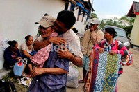Seorang warga memeluk keluarganya yang sempat terpisah saat terjadi bentrokan antarwarga.