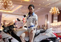 Seorang model berparas cantik berpose dengan motor Suzuki.