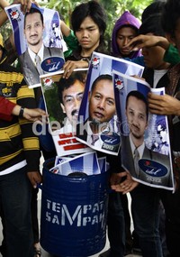 Demonstran memasukan poster-poster pimpinan KPK ke dalam tempat sampah untuk mendesak mengusut kasus Hambalang. Ramses/detikcom.