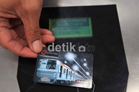 Seorang penumpang mencoba menggunakan kartu berlangganan KRL.