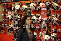 Seorang pengunjung wanita melintas di salah satu stand helm, pada pameran Jakarta Motorcycle Show (JMCS) 2012, di JCC Senayan, Jakarta, Kamis (01/11).