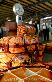 Penimbangan ulang tas untuk memastikannya tidak melampaui kuota berat maksimal 32 kg.