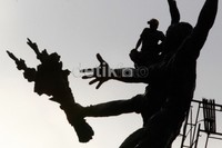 Pekerja melepas lelah disela-sela membersihkan tugu selamat datang. Tinggi patung perunggu ini dari kepala sampai kaki 5 m, sedangkan tinggi seluruhnya dari kaki hingga tangan yang melambai adalah 7 m, dan tinggi kaki patung adalah 10 m.