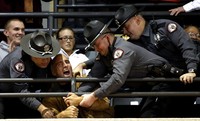 Tiga orang polisi berusaha mengeluarkan seorang demonstran yang melakukan protes dari aula Universitas Cincinnati. Reuters/Larry Downing.