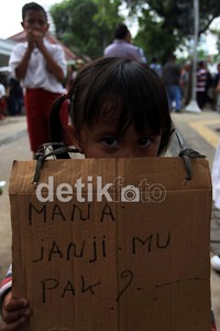 Mereka membawa poster dari bekas kardus meminta agar Jokowi tidak menggusurnya.
