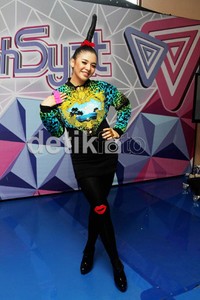 Ia bergaya dengan atasan bermotif leopard bernuansa biru-hijau. Gus Mun/detikHOT.