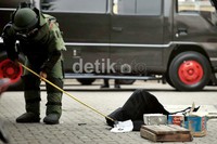 Penjinak bom memeriksa benda yang diduga bom buku di halaman Mapolsek Tanjung Duren.