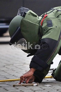 Penjinak bom berusaha membuka buku dengan pisau.