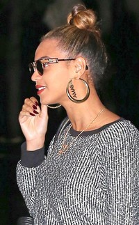 Beyonce memakai anting bulat besar bertuliskan Obama rancangan Erika Pena. (Teach/FAMEFLYNET PICTURES; eonline)