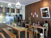 Pengunjung bisa duduk di kursi kayu yang kokoh dan tempat duduk kayu tanpa sandaran panjang, persis seperti di warung. Meski begitu, tampilan warung Haloniko! tampak modern, segar dan apik. (Flora Febrianindya/detikFood)
