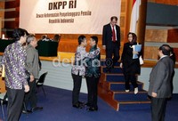 Ketua Bawaslu Muhammad (batik biru) berjabat tangan dengan anggota KPU Sigit Pamungkas. Sidang akan dilanjutkan Selasa pekan depan.