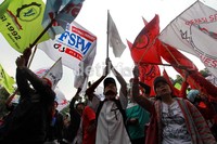 Para buruh membawa bendera organisasi masing-masing.