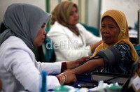 Seorang warga di cek tekanan darahnya.