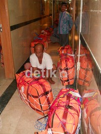 Seorang jamaah mengepak tas koper sebelum ditimbang oleh petugas bagian penimbangan.