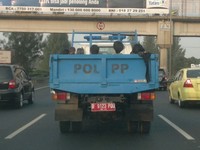 Walaupun ada larangan untuk menaikkan penumpang pada kendaraan terbuka,tetapi truk Satpol PP ini membawa beberapa orang di tol JORR km 36.(Foto: Yusro).