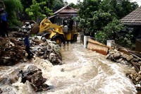 Petugas penanggulan banjir dari Depok berusaha membendung mengunakan alat berat. Ramses/detikcom.
