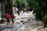 Air yang menggenangi jalanan dimafaatkan anak-anak untuk bermain.