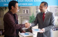 Ridwan Yuwono, Presiden Direktur PT Akasia Prima Sejahtera (kanan) berjabat tangan dengan Andry Tjandrawinata, Sales Manager Home Loan Panin Bank seusai penandatangan kerjasama KPR Panin Bank untuk pembelian unit Camden House. (dok Panin Bank)
