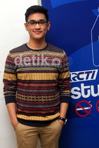 Ia mengenakan sweater warna-warni teduh dan celana chino coklat. Gus Mun/detikHOT.