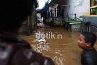 Sejumlah warga beraktivitas di saat banjir di kawasan Kampung Melayu Kecil 1, Poncol, Bukit Duri, Jakarta Selatan, Senin (19/11/2012).
