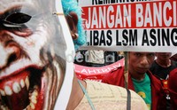 Para pendemo membawa berbagai spanduk dan poster di depan Gedung Kemenkum HAM.