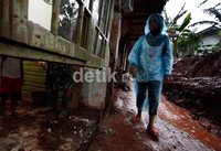 Beberapa warga membersihkan lumpur di dalam rumahnya.